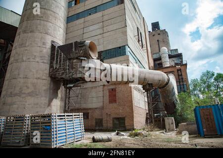 Temirtau, Kazakhstan : usine de ciment soviétique dépassée. Ciment construction industrielle, tube métallique.ciel bleu. Banque D'Images