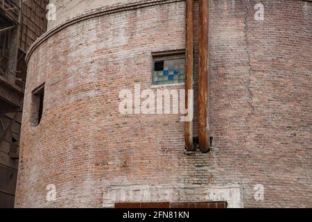 Temirtau, Kazakhstan - 09 juin 2012 : gros plan de la tour de silo de l'usine de ciment soviétique. Mur de briques fissuré. Tuyaux rouillés. Le verre brisé bloque les fenêtres. Banque D'Images