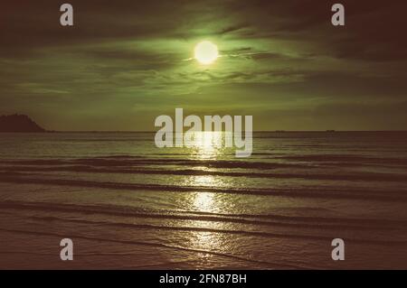 Ciel coloré avec nuage et pleine lune lumineuse sur le paysage marin en soirée. Sérénité nature, extérieur la nuit. Ton sépia. Banque D'Images