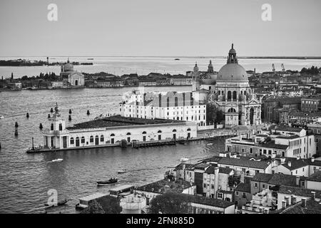 Venise avec l'église Santa Maria della Salute de l'autre côté du Grand Canal, en Italie. Paysage urbain vénitien panoramique noir et blanc Banque D'Images
