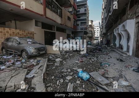 Gaza, Territoires palestiniens. 15 mai 2021. Les voitures sont endommagées à la suite d'une frappe aérienne israélienne sur la rue Al Talatene dans le centre de la ville de Gaza, dans le contexte de l'escalade de la violence israélo-palestinienne. Credit: Mohammed Talatene/dpa/Alay Live News Banque D'Images