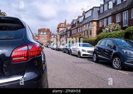 Voitures garées dans la rue de maisons haut de gamme à Chelsea. Banque D'Images