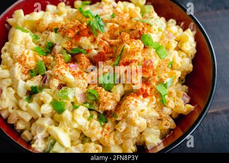 Salade de pâtes aux œufs décomposés dans un bol de service : un grand bol de salade de macaroni à base d'œufs durs Banque D'Images