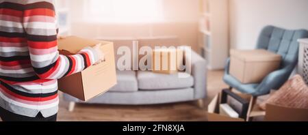 Femme portant une boîte en carton dans ses mains Banque D'Images