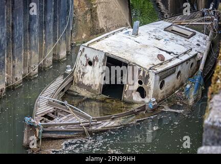 Cabine de croisière en bois abandonnée pourrie à moitié submergée dans la rivière - épave du navire Banque D'Images