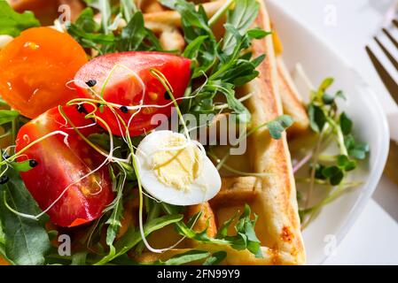 Délicieux petit déjeuner savoureux - œufs durs, gaufres de pommes de terre et tomates, vue de dessus Banque D'Images