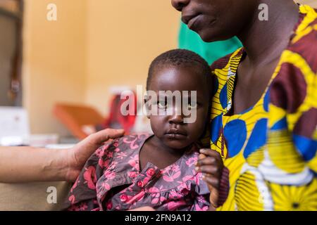 Une jeune fille malade avec sa mère dans une clinique médicale à Mbale, dans la région rurale de l'est de l'Ouganda Banque D'Images