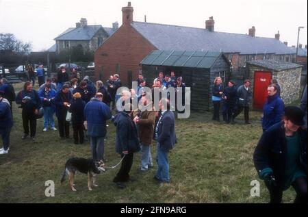 Une foule de supporters de football non-League lisant le programme de match et attendant d'entrer dans le terrain de football avant un match Banque D'Images