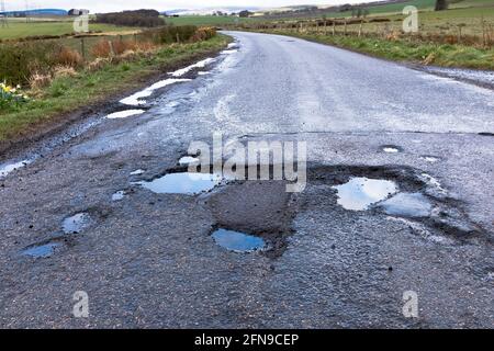 dh Roads ECOSSE Royaume-Uni trou profond route flaque endommagé surface après Covid 19 hiver dommages des nids-de-poule en gros plan pays de la pothole mauvaise qualité Banque D'Images