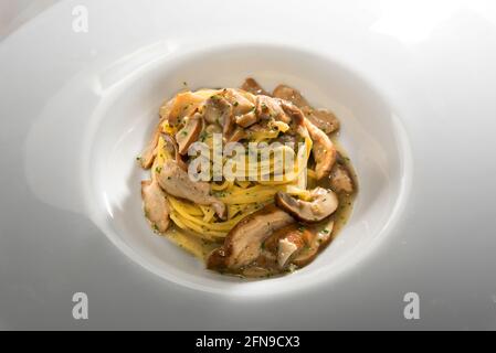Tajarin aux champignons porcini ou Boletus edulis, pâtes de fettuccine d'Alba, Langhe, Piémont, Italie, gros plan dans un plat blanc Banque D'Images