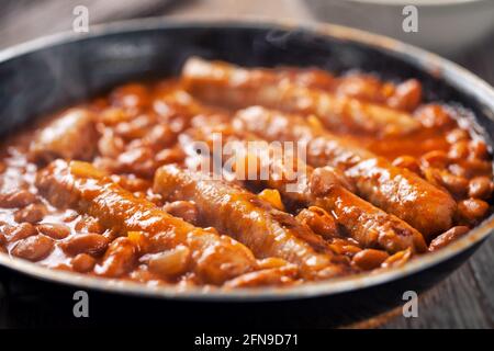 Saucisse et haricots avec sauce tomate sur une casserole. Banque D'Images