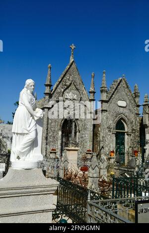 Statue de la Vierge Marie et mausolées en pierre de granit gris dans un cimetière à côté de l'église et du couvent de Santo Antonio, Caminha, province de Minho, Portugal Banque D'Images