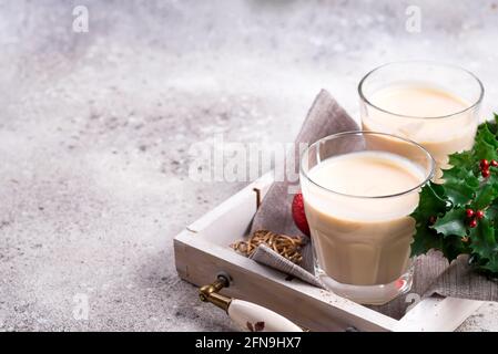 Hiver boisson chaude épicée aubergine dans un verre avec le cinamon dans la plaque de pierre, les branches de givre de glace sur la table de pierre légère Banque D'Images