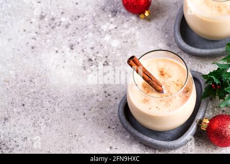 Hiver boisson chaude épicée aubergine dans un verre avec le cinamon dans la plaque de pierre, les branches de givre de glace sur la table de pierre légère Banque D'Images