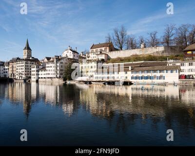 Front de mer de la rivière Limmat dans la vieille ville de Zurich, Suisse. Vue vers l'ouest depuis Limmatquai vers Lindenhof et l'église Saint-Pierre. Banque D'Images