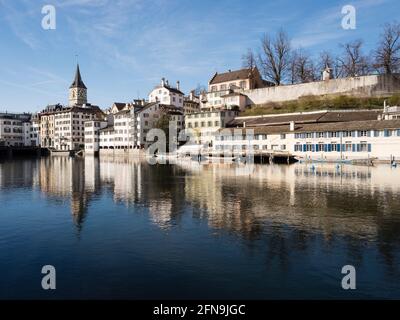 Front de mer de la rivière Limmat dans la vieille ville de Zurich, Suisse. Vue vers l'ouest depuis Limmatquai vers Lindenhof et l'église Saint-Pierre. Banque D'Images