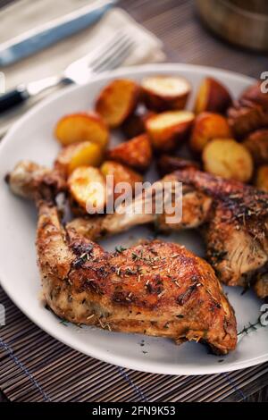 Braiser les cuisses de poulet avec les pommes de terre sur une assiette Banque D'Images