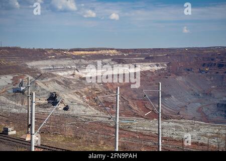 Une ligne électrique, une pelle à pied, un train de chemin de fer sur fond d'une partie d'une carrière de minerai de fer et d'équipements miniers. Arrière-plan. Copier les Banque D'Images