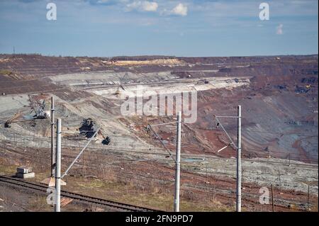 Une ligne électrique, une pelle à pied, un train de chemin de fer sur fond d'une partie d'une carrière de minerai de fer et d'équipements miniers. Arrière-plan. Copier les Banque D'Images