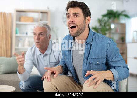 père et fils regardant la télévision ensemble à la maison Banque D'Images