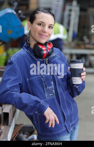 femme qui tient un café pendant une pause sur le lieu de travail Banque D'Images