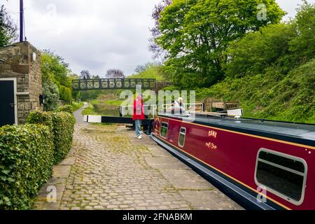 Les gens sur un bateau à narrowboat Canal lorsqu'il passe à travers les écluses Sur le canal de Macclesfield à Odd Rode Scholar Green Cheshire Banque D'Images
