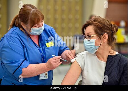 Natalyia Dasiukevich reçoit son vaccin Covid-19 de l'infirmière Carol McGlion au Allander Sports Center de Glasgow, alors que l'Écosse a passé la marque de trois millions pour la vaccination contre le coronavirus. Date de la photo: Vendredi 14 mai 2021. Banque D'Images