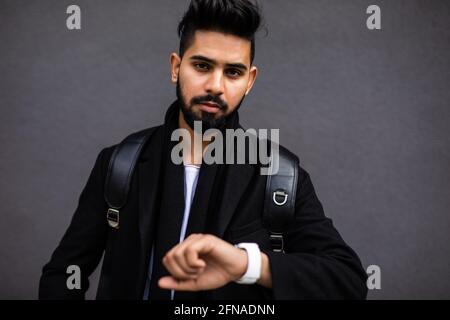 Je serai à l'heure. Beau jeune homme en tenue de cérémonie regardant sa montre tout en se tenant dans la rue Banque D'Images