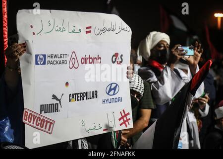 Doha, Qatar. 15 mai 2021. Un participant porte un panneau indiquant « votre soutien à la Palestine = boycott » lors d'un rassemblement de solidarité avec les Palestiniens devant la mosquée Imam Mohammed Abdel-Wahhab de Doha, auquel a assisté Ismail Haniyeh, le chef du bureau politique du Hamas, dans le contexte de l'escalade de la violence israélo-palestinienne. Credit: Mahmoud Hefnawy/dpa/Alay Live News Banque D'Images