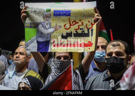 Doha, Qatar. 15 mai 2021. Un participant porte un écriteau intitulé « nous ne partirons pas, Jérusalem nous a rassemblés » lors d'un rassemblement en solidarité avec les Palestiniens devant la mosquée Imam Muhammad Abdel-Wahhab de Doha, auquel a assisté Ismail Haniyeh, le chef du bureau politique du Hamas, dans le contexte de l'escalade de la violence israélo-palestinienne. Credit: Mahmoud Hefnawy/dpa/Alay Live News Banque D'Images