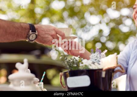 gros plan de la main de femme prenant une tasse de café donné par main masculine en plein air dans la nature Banque D'Images