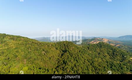 Vue aérienne du magnifique paysage de montagne avec des sommets couverts de forêt et le ciel bleu le matin. Banque D'Images