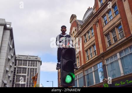 Londres, Royaume-Uni. 15 mai 2021. Un manifestant monte au-dessus d'un feu de circulation sur Kensington High Street près de l'ambassade Isreali pour soutenir la Palestine. Credit: Vuk Valcic/Alamy Live News Banque D'Images