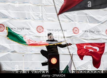 Londres, Royaume-Uni. 15 mai 2021. Un homme portant des drapeaux lors de la manifestation contre la violence de l'État en solidarité avec la Palestine le 15 mai 2021 à Londres, en Grande-Bretagne. Les tensions à Jérusalem ont entraîné des frappes aériennes transfrontalières entre Israël et des militants à Gaza, tuant au moins 119 Palestiniens et 8 Israéliens crédit: May James/ZUMA Wire/Alamy Live News Banque D'Images