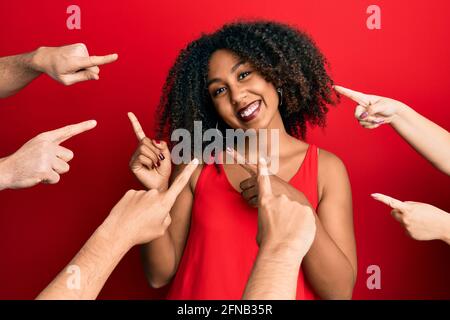 Belle femme afro-américaine avec cheveux afro-américains avec les doigts autour se pointer vers elle-même sourire et regarder la caméra pointer avec deux mains et Banque D'Images