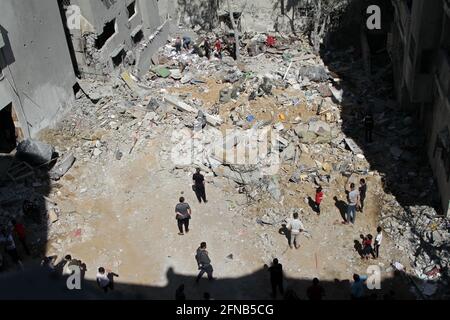 Gaza. 15 mai 2021. Les Palestiniens inspectent les ruines de maisons détruites par les frappes aériennes israéliennes dans le camp de réfugiés de Shati, dans la ville de Gaza, le 15 mai 2021. Credit: Rizek Abdeljawad/Xinhua/Alamy Live News Banque D'Images