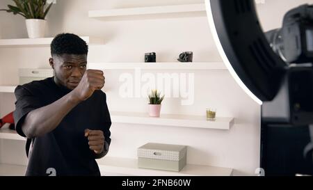 Un homme noir portant une ceinture de remise en forme punch boxe dans les airs. Ralenti. Banque D'Images