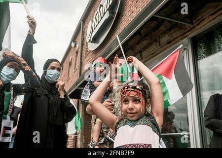 Une jeune fille agite un drapeau palestinien, lors d'un grand rassemblement libre de Palestine au Musée arabe américain. Des centaines d'habitants de Detroit et de Dearborn Michigan sont descendus dans les rues en mars pour protester contre l'expulsion forcée de Palestiniens de Sheikh Jarrah à Jérusalem-est et les frappes aériennes en cours sur Gaza par Israël qui ont tué 145 Palestiniens, dont 41 enfants. Les manifestants ont défilé à travers Dearborn depuis le Musée arabe américain, ont tenu des drapeaux palestiniens et ont porté des kafias traditionnels. Banque D'Images