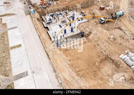 pompe à béton travaillant sur une fondation d'un nouvel immeuble d'appartements. photographie aérienne avec drone Banque D'Images