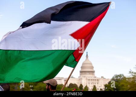 Washington, DC, États-Unis. 15 mai 2021. En photo : un manifestant devant la foule de plus d'un millier de personnes fait la vague d'un drapeau palestinien alors que la Marche pour la Palestine approche le Capitole des États-Unis. La manifestation marque le 73e anniversaire de la Nakba, la prise de Palestine par Israël en 1948. Cette date revêt une plus grande importance cette année en raison de l'invasion de la mosquée Al Aqua par Israël à Jérusalem et des frappes aériennes à Gaza. Crédit : Allison Bailey/Alamy Live News Banque D'Images