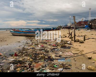 Kaimana, Arguni Bay, Indonésie - février 2018 : problème de pollution. Bateaux en bois et plein de déchets sur la plage à marée basse au port d'un petit Banque D'Images