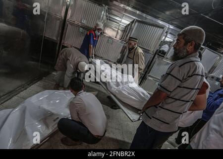 Gaza, Territoires palestiniens. 16 mai 2021. Les Palestiniens inspectent les corps de ceux qui ont été tués lors d'une frappe aérienne israélienne, dans le contexte de l'escalade de la violence israélo-palestinienne. Credit: Mohammed Talatene/dpa/Alay Live News Banque D'Images