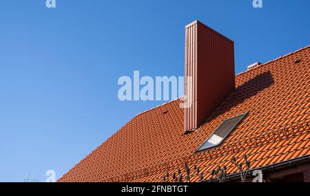 Toit profilé en métal ondulé rouge installé sur une maison moderne. Le toit de tôle ondulée. Toiture en profil métallique de forme ondulée. Toit moderne en Banque D'Images