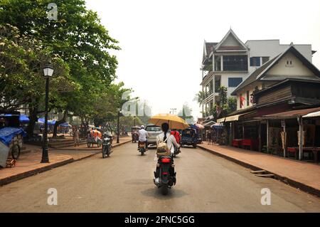 Laotien gens étrangers voyageurs à vélo de conduire sur la circulation de rue sur la route et à pied sur le sentier de randonnée pédestre visite Ancienne ville de Lua Banque D'Images