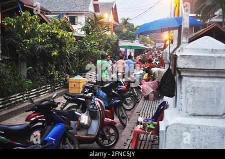 Les laotiens et les voyageurs étrangers arrêtent la moto au parking pour visite de voyage acheter des boissons dans la cuisine locale de rue lao Marché de nuit bazar à Louang Banque D'Images