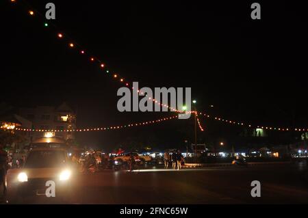 Laotien gens étrangers voyageurs à vélo de conduire sur la circulation de rue sur la route et à pied sur le sentier de randonnée pédestre visite Dans la nuit à lu Banque D'Images