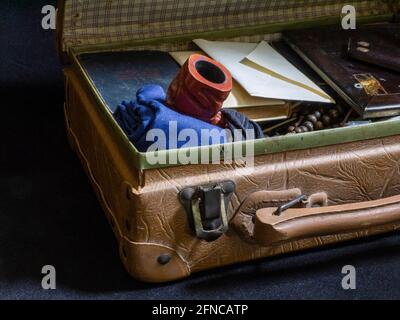 Une valise ouverte d'un émigrant, avec un tuyau, des lettres, des livres. Banque D'Images