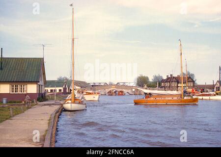 La rivière Thurne à Potter Heigham, Norfolk Broads, mai 1960, avec le pont routier médiéval et le pont ferroviaire (depuis démoli) au-delà Banque D'Images