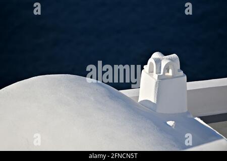 Maison traditionnelle en adobe des Cyclades sur le toit et la cheminée contre le bleu de la mer Egée dans l'île de Santorin, Cyclades Grèce. Banque D'Images