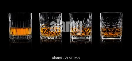 Jeu de quatre verres en cristal différents avec whisky scotch sur fond noir avec réflexion. Banque D'Images